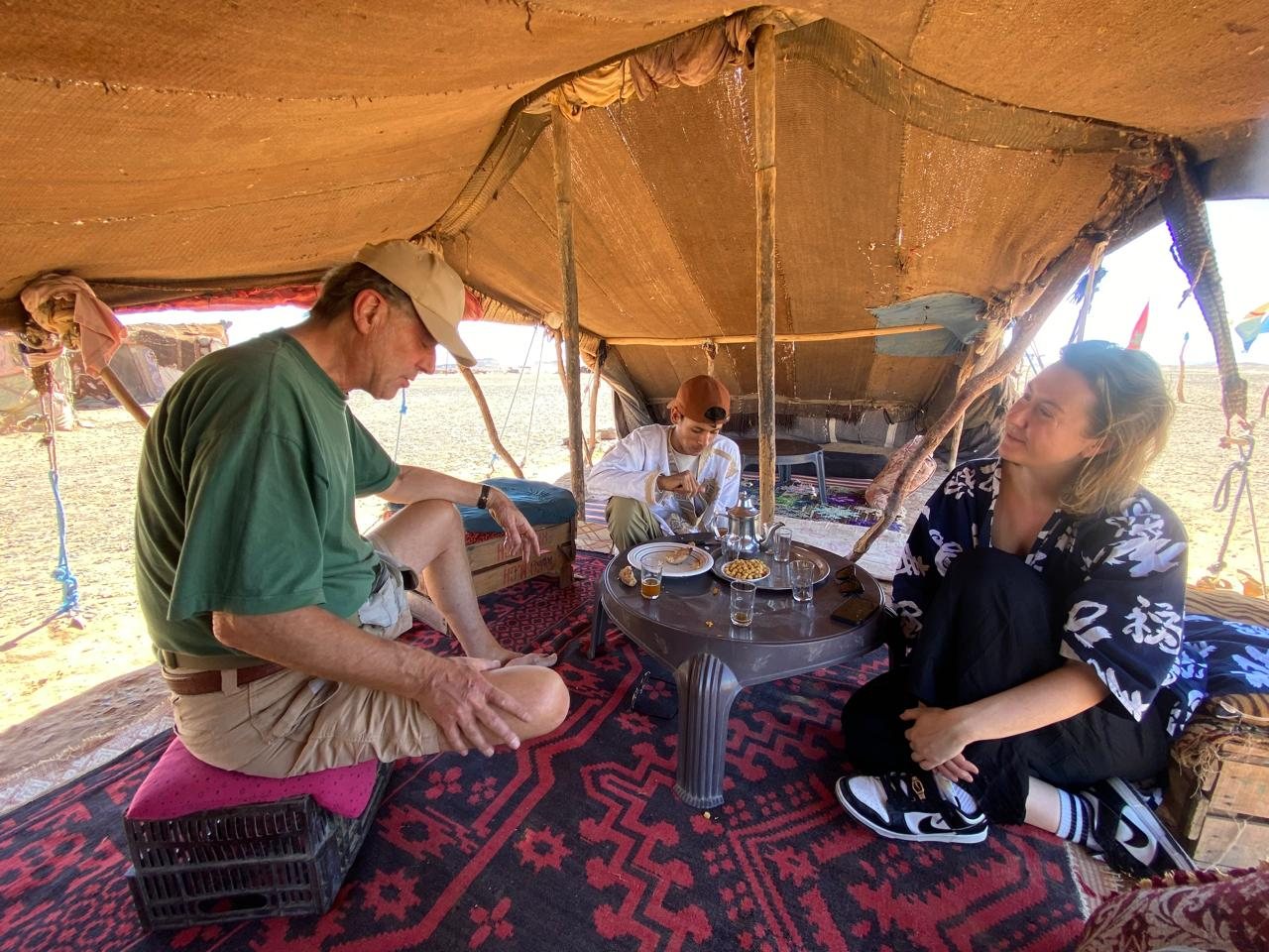 Travelers sharing mint tea in a Sahara desert camp